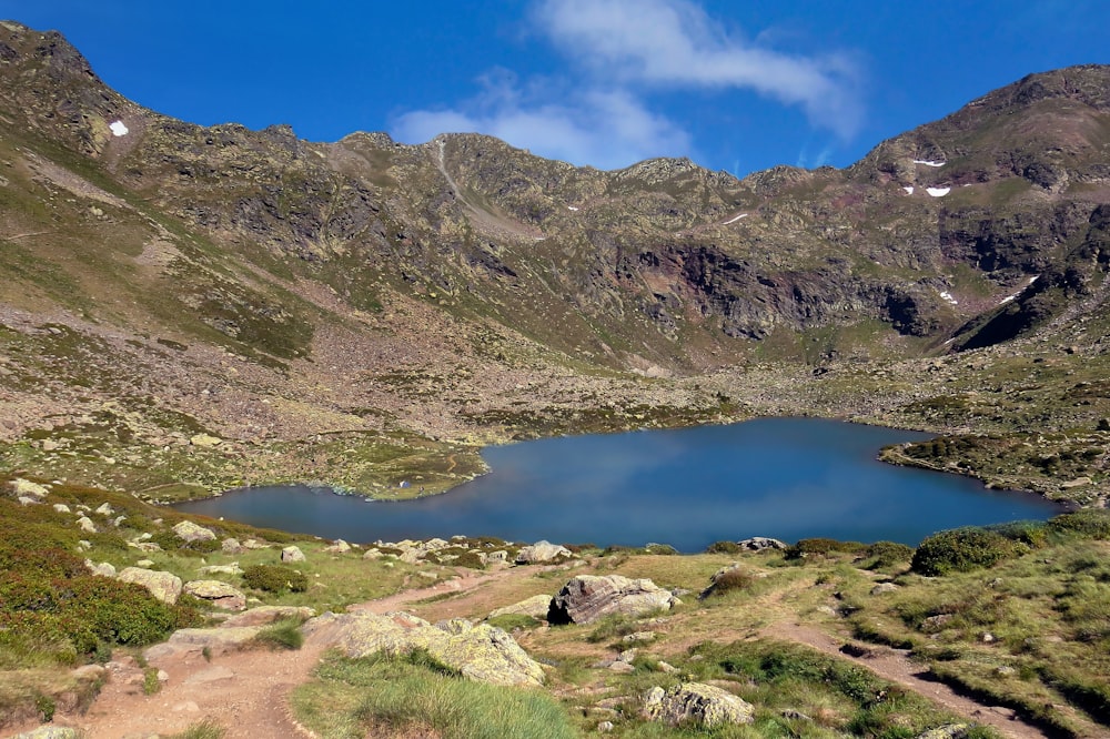 lake in the middle of mountains during daytime