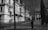 grayscale photo of person walking on sidewalk