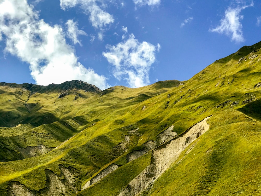 green grass covered mountain under blue sky during daytime