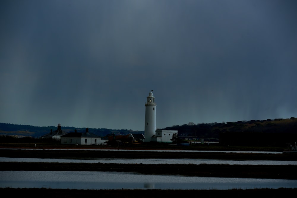 white lighthouse near body of water during daytime