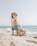 brown and white short coated dog on beach during daytime