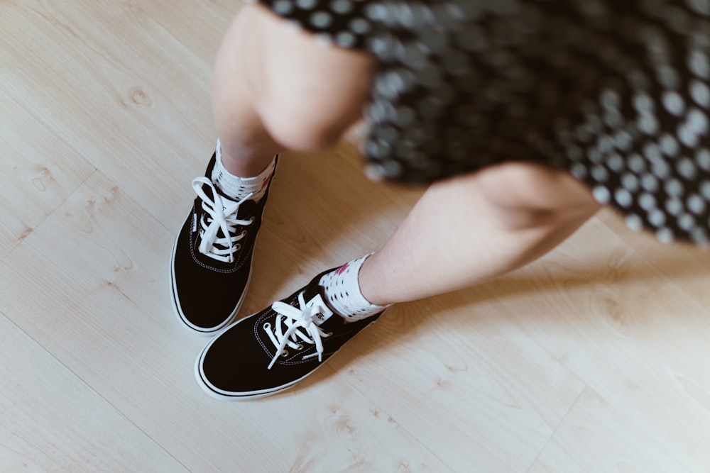 person wearing black and white sneakers