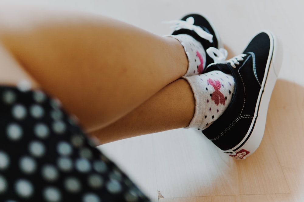 person wearing black and white nike sneakers