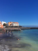 A vibrant beach scene in Brazil with clear blue water and golden sand under a sunny sky.