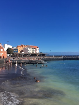 A vibrant beach scene with tourists enjoying water sports under clear skies.