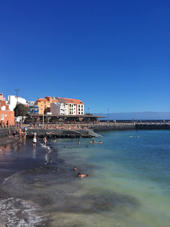 A vibrant seaside scene with a family wearing colorful cotton outfits from lalyazur, enjoying a sunny day.