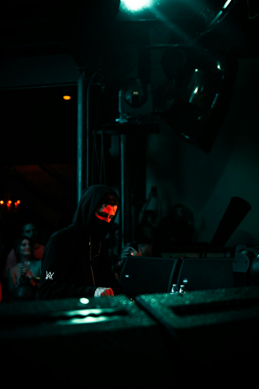 man in black hoodie standing near stage