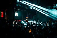 A dynamic live concert moment, capturing the energy of the crowd and the vibrant stage lights.