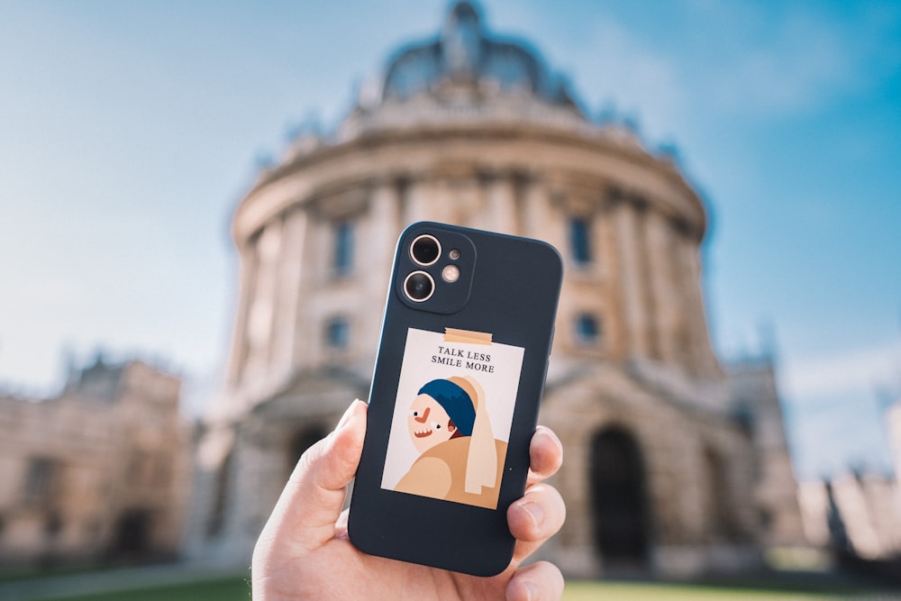 person holding iphone with black case