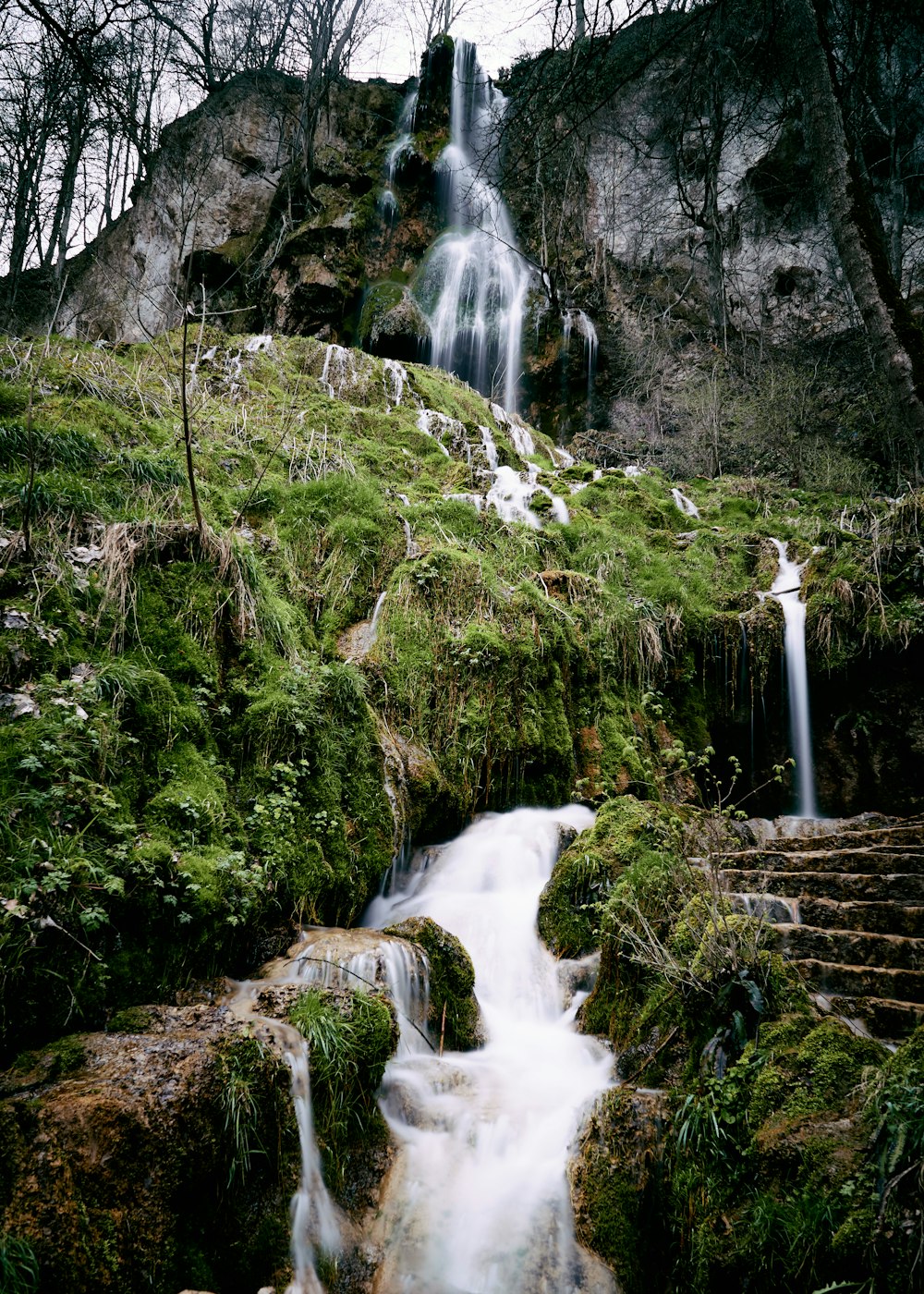 water falls on green grass field during daytime