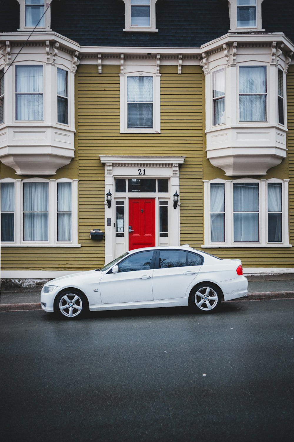 white sedan parked in front of white house