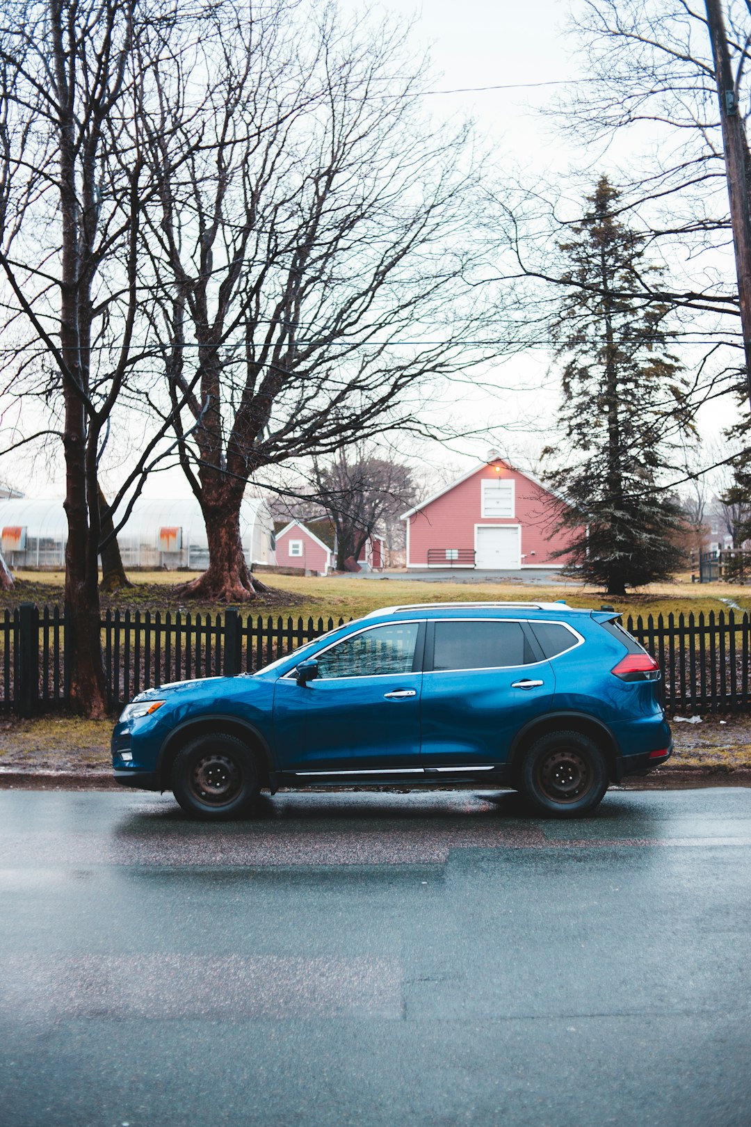 blue car parked on sidewalk during daytime