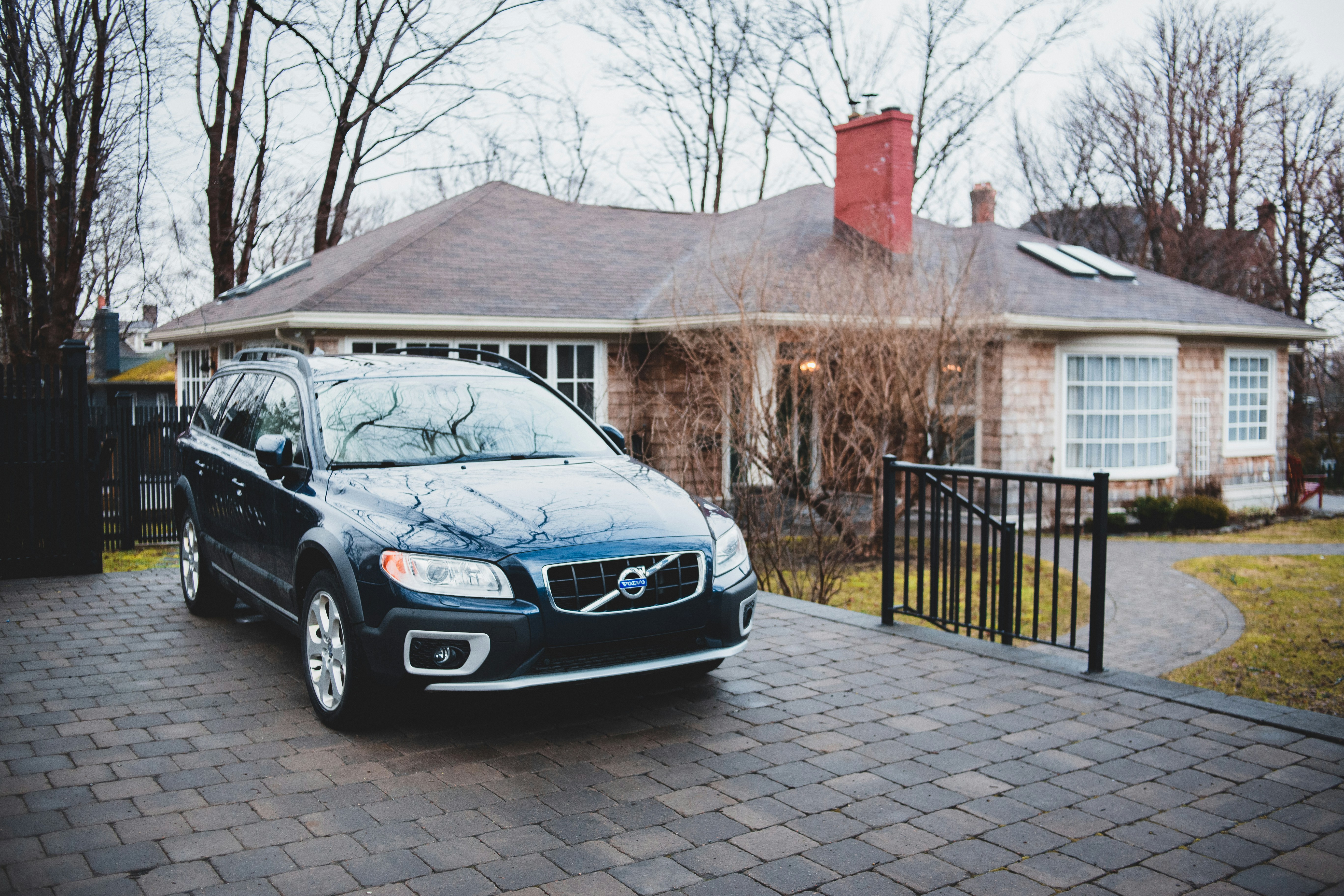 Family loading a full electric vehicle that is charging in a home driveway