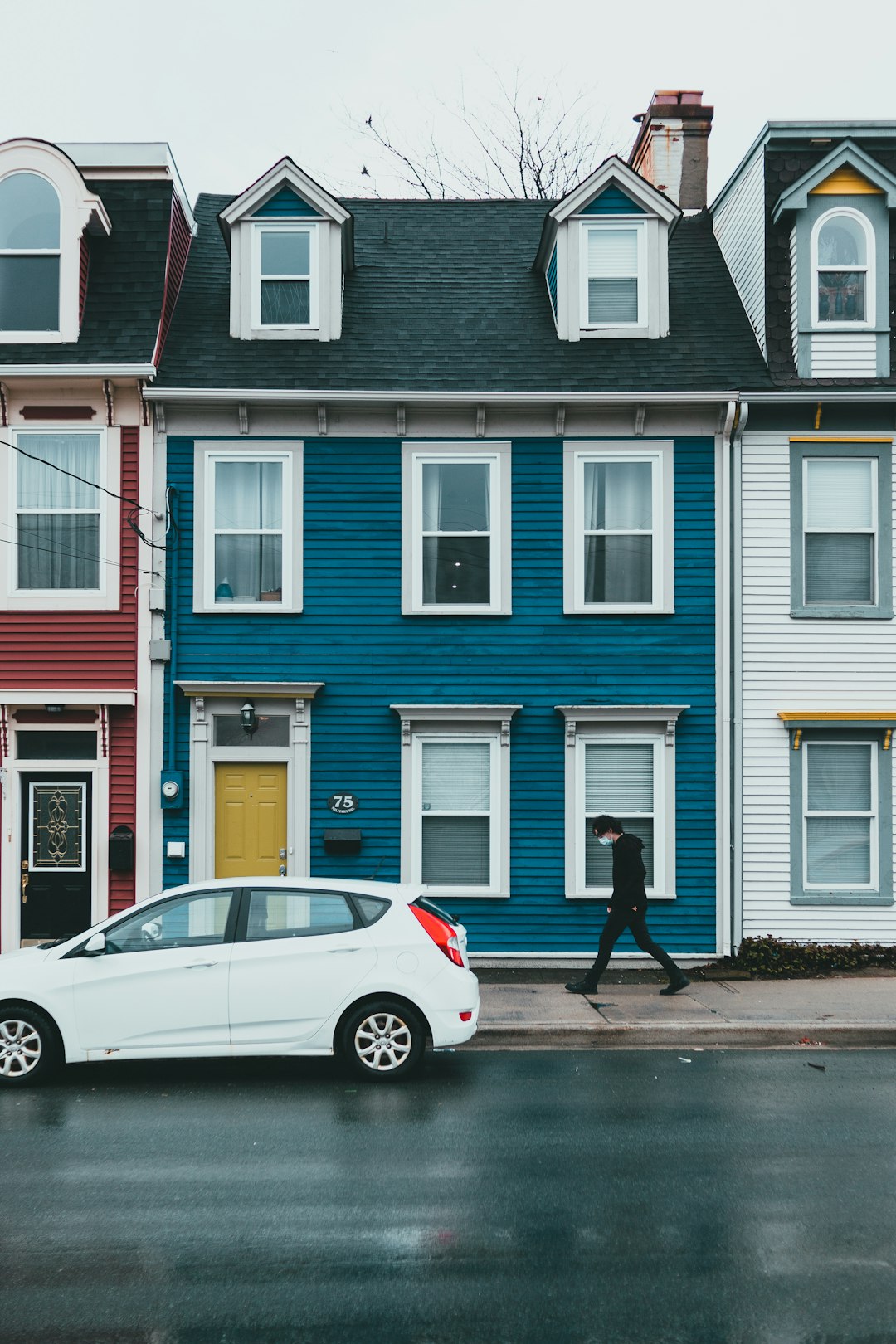 white sedan parked beside brown and white concrete building during daytime