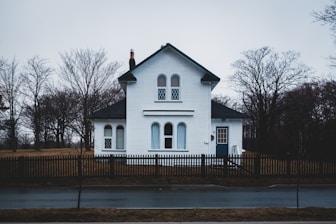 white wooden house near bare trees during daytime