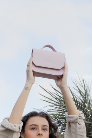 A customer happily holding a braided leather purse outdoors.