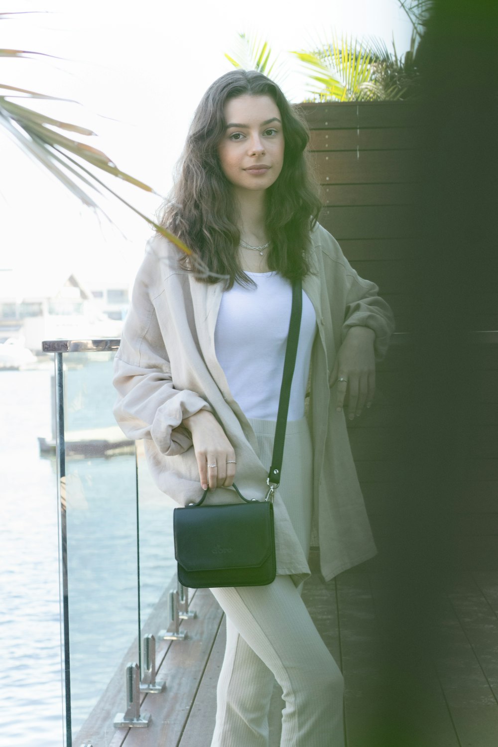 woman in white coat holding green leather handbag