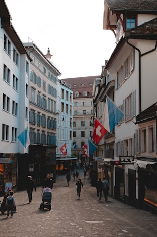 A charming old town street in Switzerland with colorful buildings and cobblestone pavement under a bright sky.
