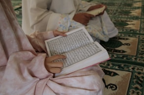 person reading book on bed