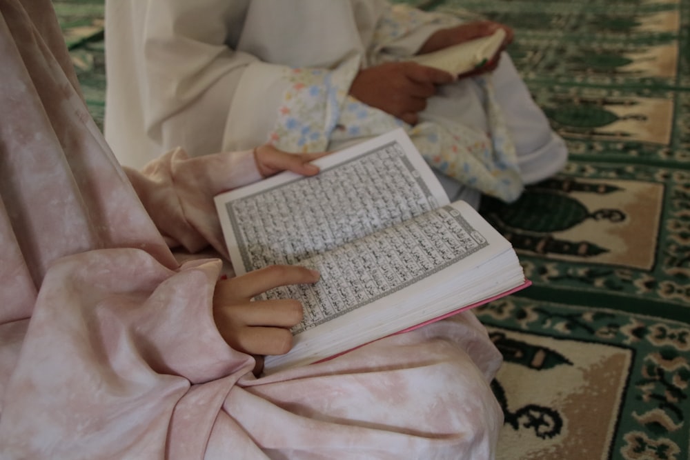 person reading book on bed