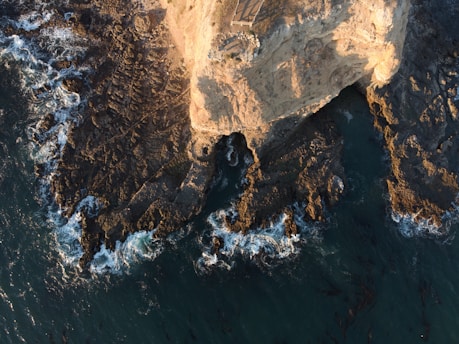 A stunning view of the rugged coastline of Baja California with waves crashing against the cliffs.