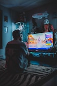 man in red shirt watching tv