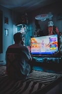 man in red shirt watching tv
