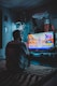 man in red shirt watching tv