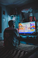 man in red shirt watching tv