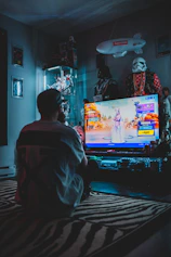 man in red shirt watching tv