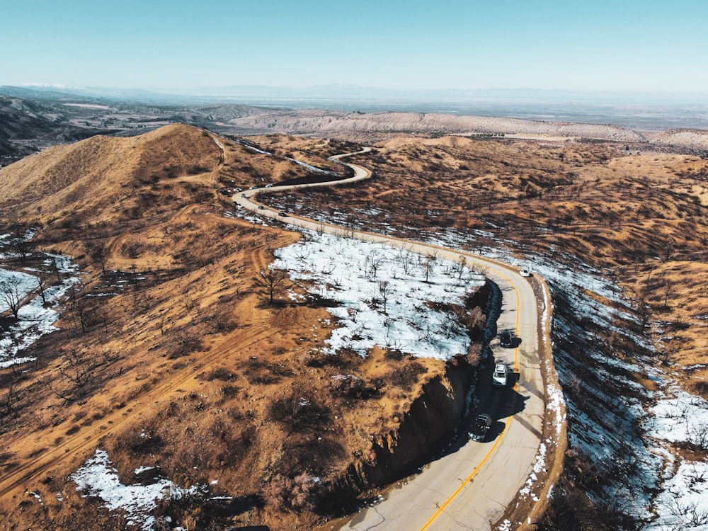 aerial view of road in the middle of brown field