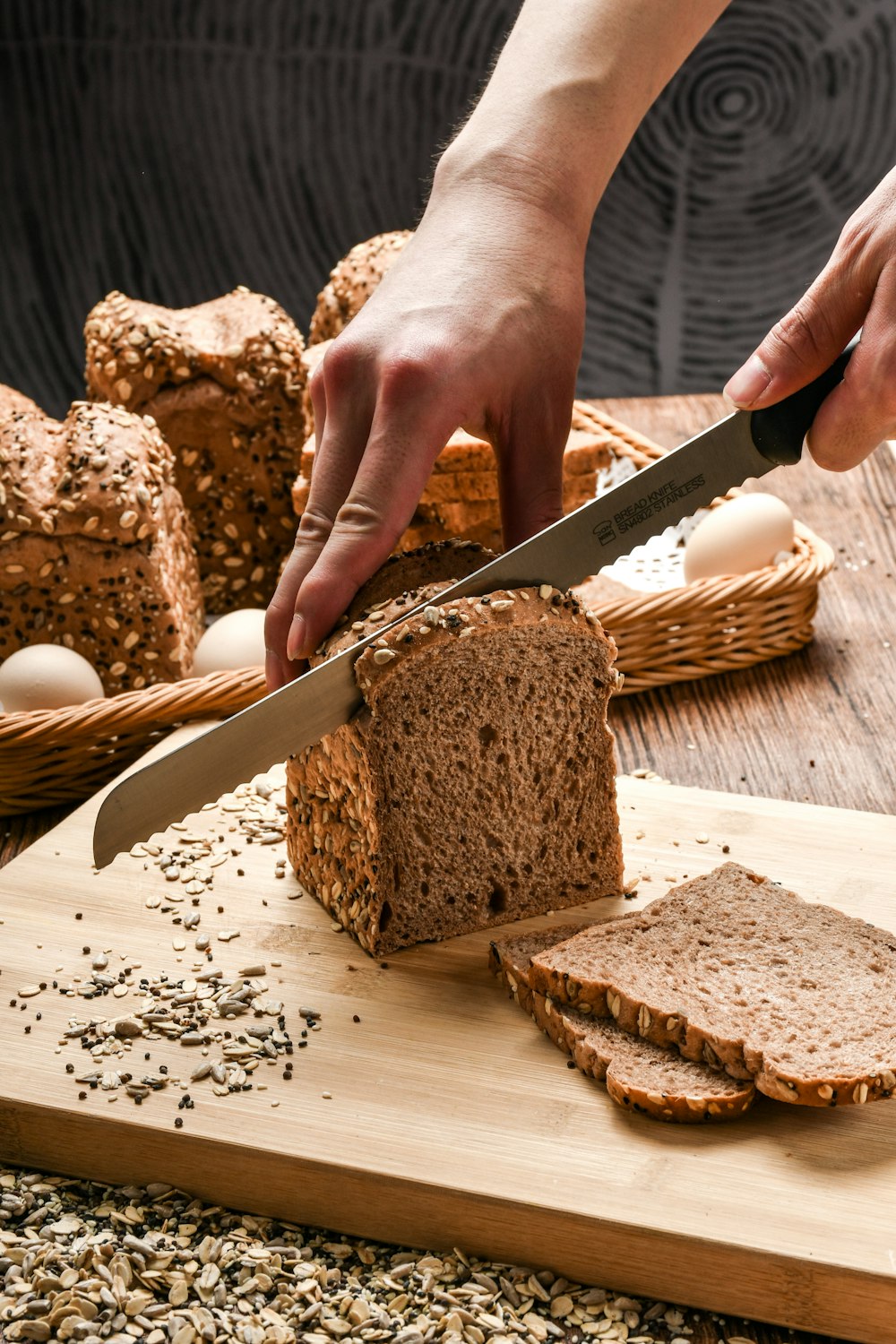 Person mit Messer beim Schneiden von Brot