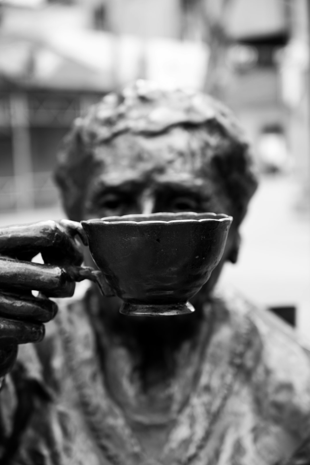 grayscale photo of person holding ceramic teacup