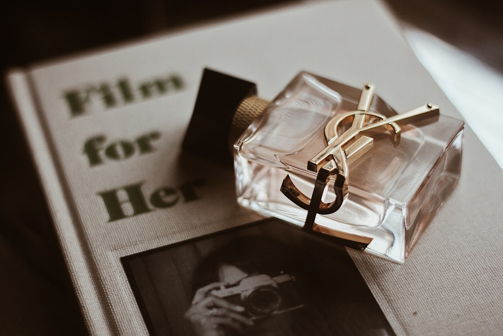 clear glass perfume bottle on black and white textile