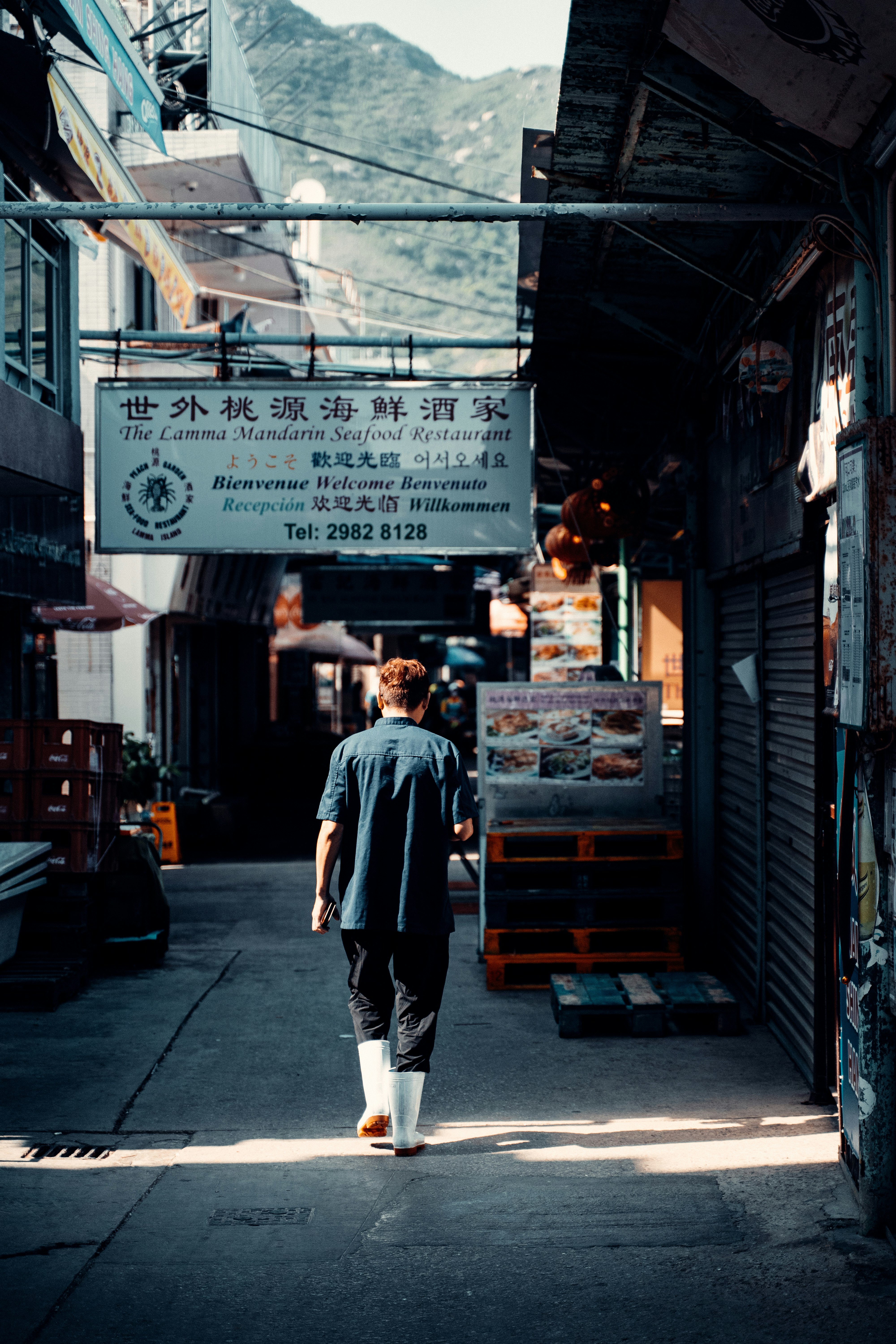 man in gray long sleeve shirt walking on street during daytime
