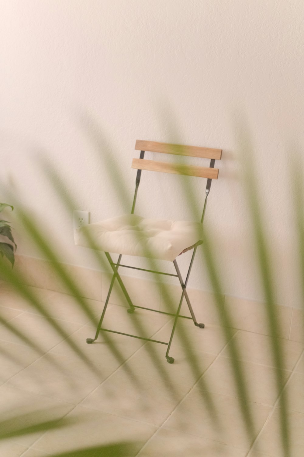 녹색과 흰색 벽 옆에 갈색 나무 접이식 의자