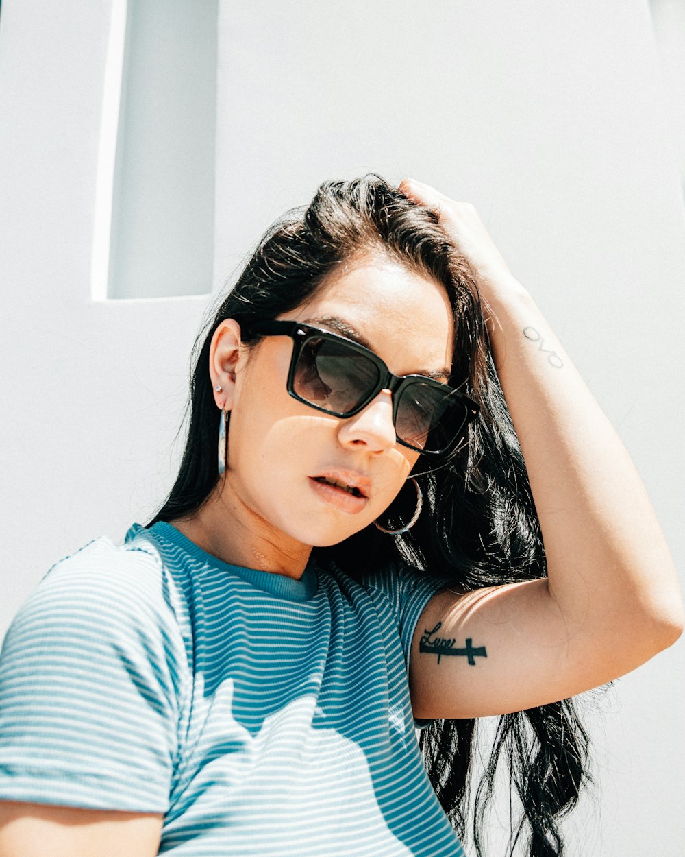woman in blue and white striped shirt wearing black sunglasses