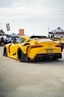 A car enthusiast admiring a custom bodykit at a car show.