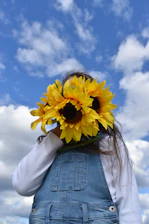 Smiling children holding sunflowers in a bright, outdoor setting.