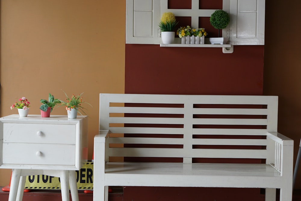 red and white wooden bench beside red and white flower on white wooden table