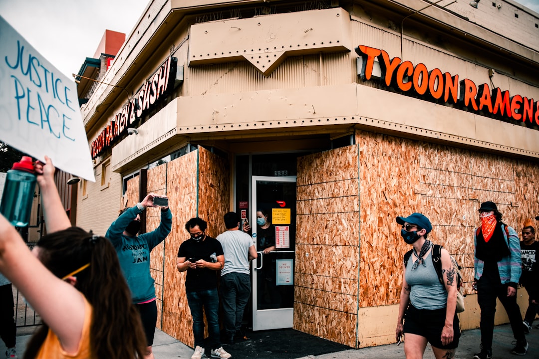 people walking in front of brown concrete building during daytime