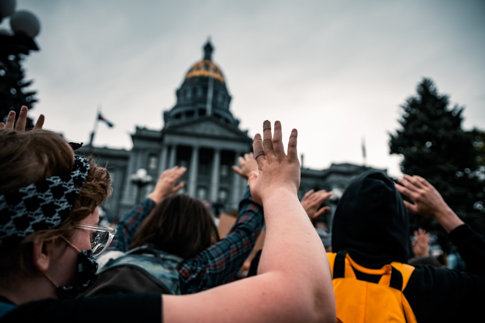 people raising their hands during daytime