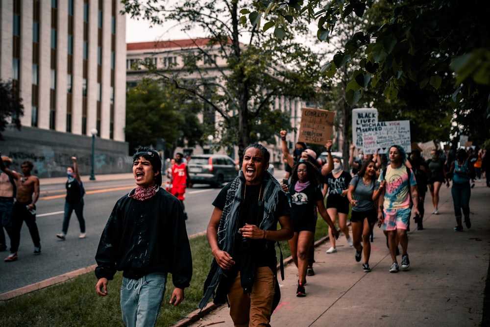 group of people standing on sidewalk during daytime