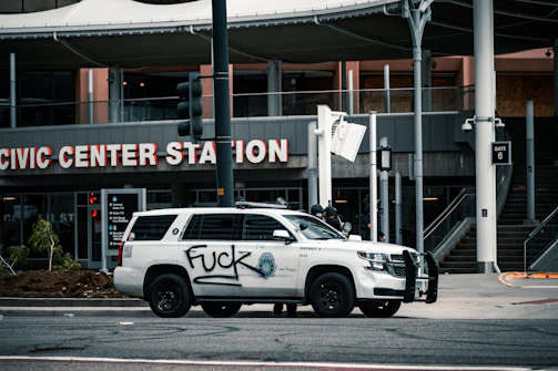 A police car parked near a graffiti-covered wall in a Chicago neighborhood.