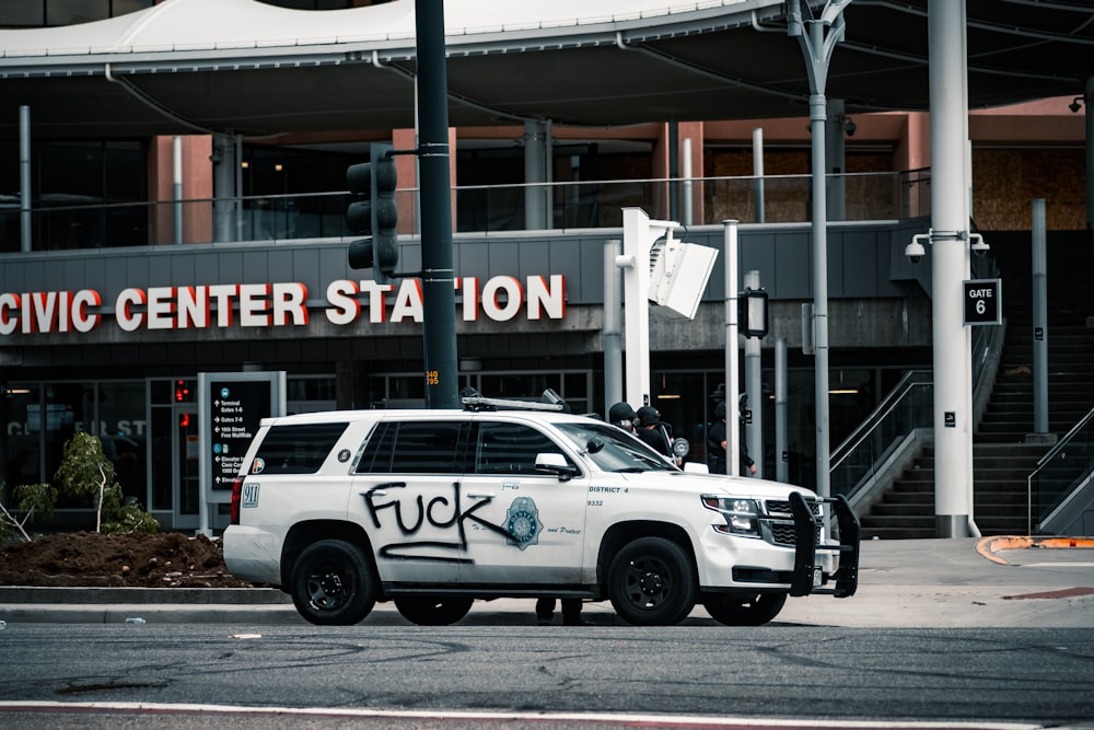 SUV blanco estacionado cerca del edificio durante el día