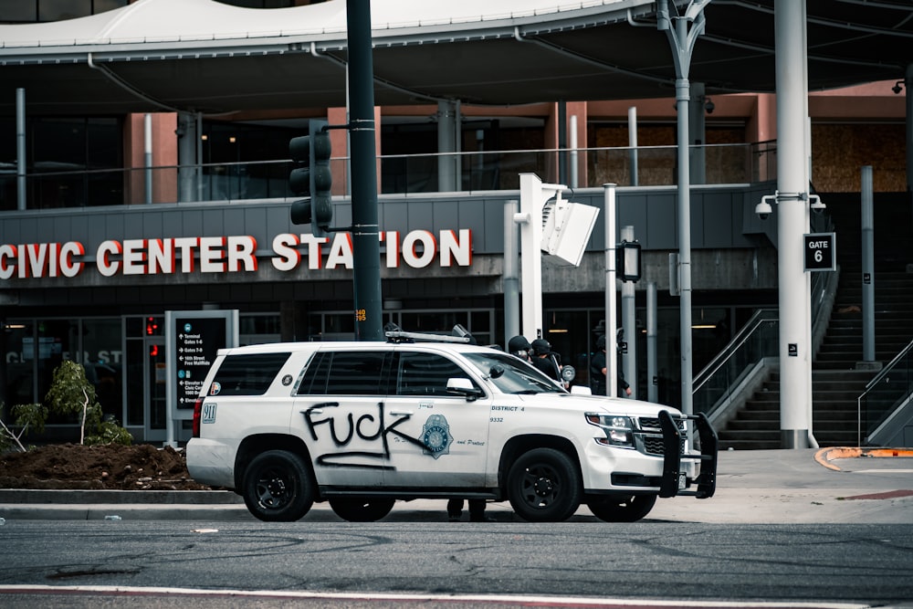 white suv parked near building during daytime