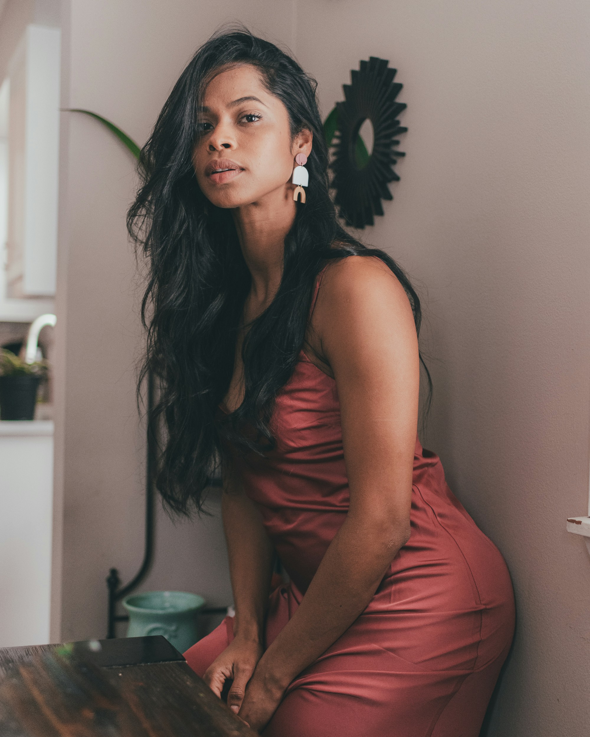 woman in pink sleeveless dress sitting on white ceramic sink