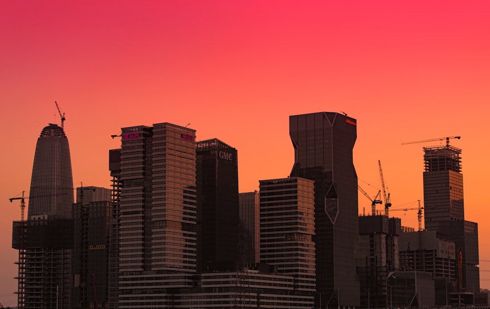 city buildings under orange sky during sunset