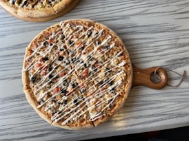 brown round pizza on brown wooden table