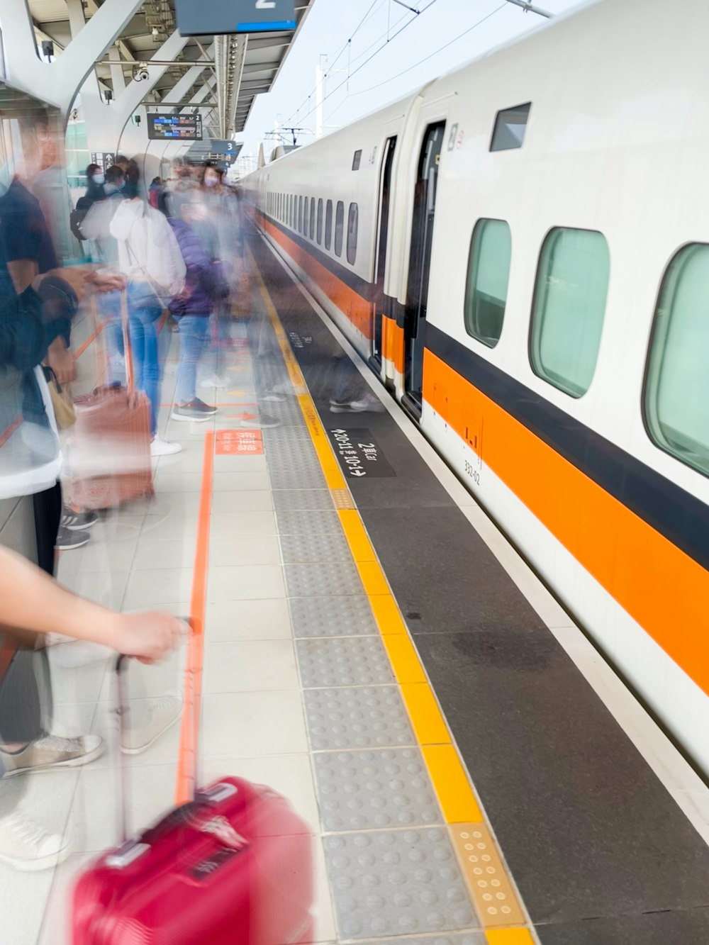 people standing beside white and yellow train during daytime